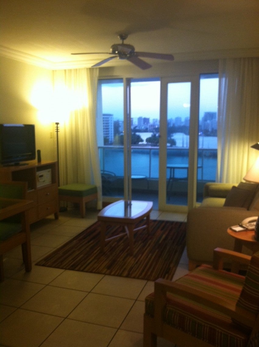 Living room with outdated furniture and television.