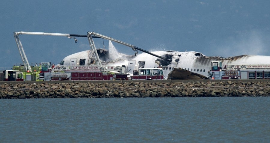 Fire trucks subdue the flames at the Asiana crash scene (AP Photo/Noah Berger).