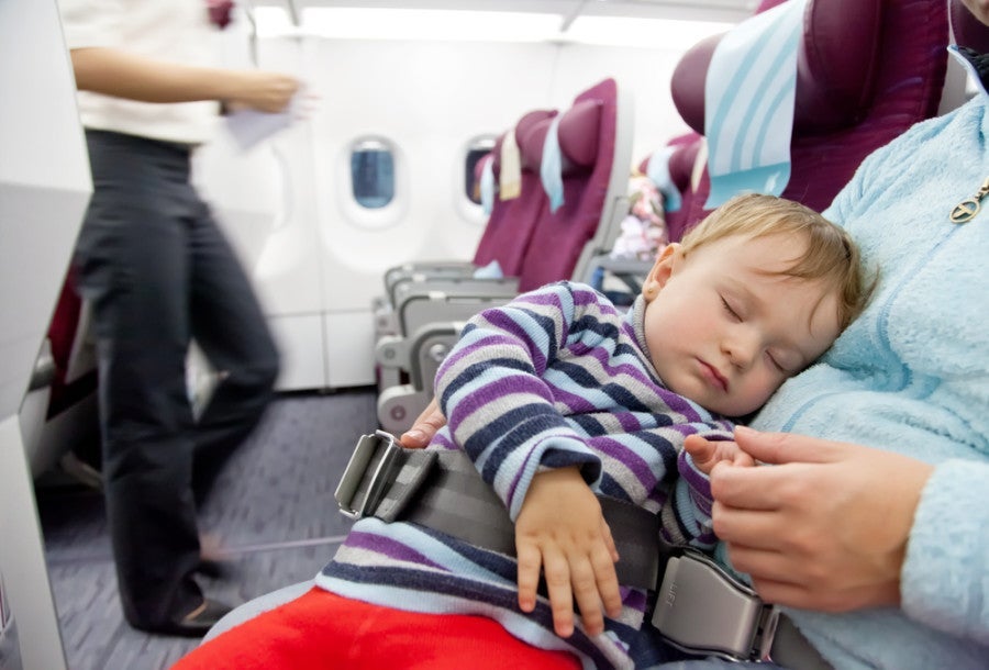 Most airlines allow children under two to be seated on the lap. Photo courtesy of Shutterstock.