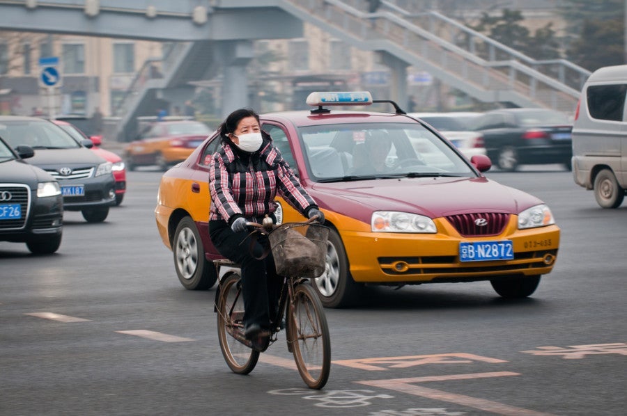 A local Beijing resident wears a mask to block out the city's obscene smog. Photo courtesy of Shutterstock.