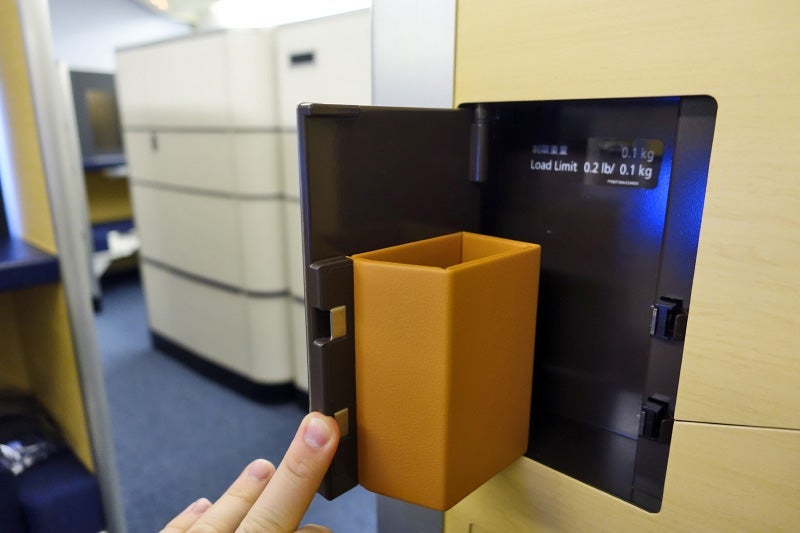 Each first-class seat has plenty of storage, including a glasses compartment.