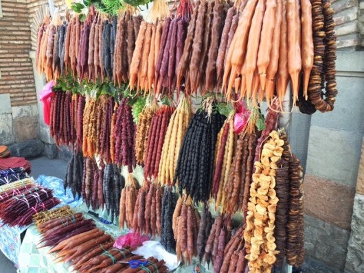 Delicious Churchkhela candies hanging for sale at a roadside stand.