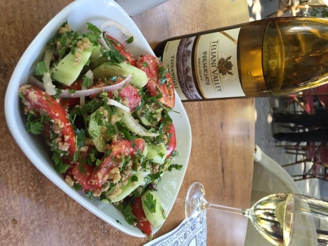 Cucumber and tomato salad served with crushed walnuts and a delicious bottle of Tsinandali.