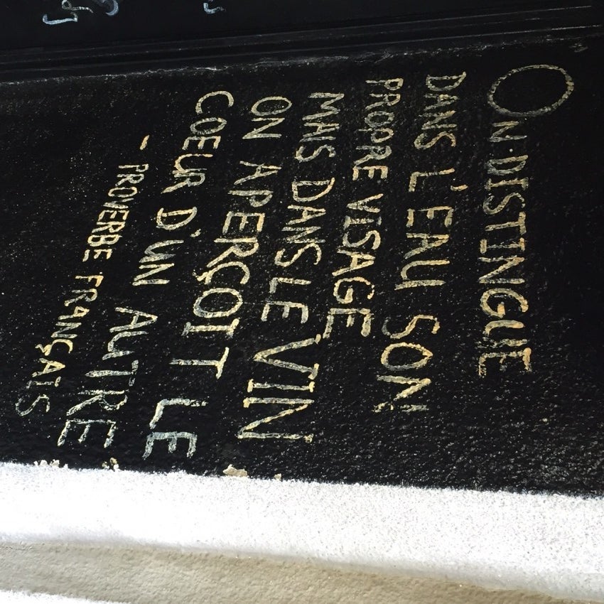 A sign in the doorway at Vino Underground. "In water, one can make-out their own reflection. However, in wine one can appreciate the heart of another."