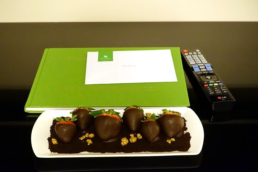 A welcome gift of chocolate-covered strawberries, set next to a book about the hotel's history.