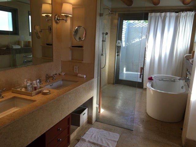 A look at the oversized bathroom with tub and doors leading to a private outdoor shower.