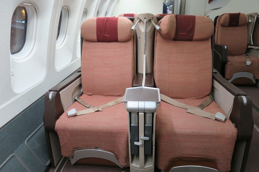 The in-flight entertainment screens are stored between the seats.