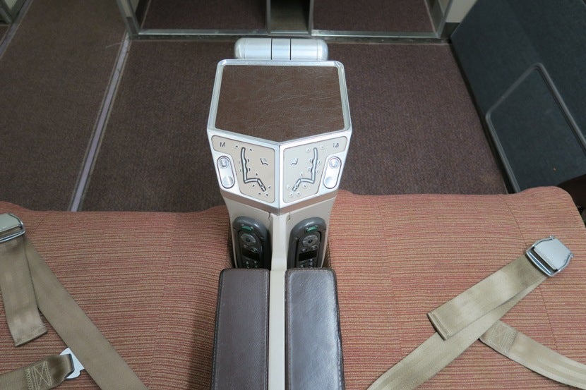 The seat controls and in-flight entertainment controls are in the console between seats.