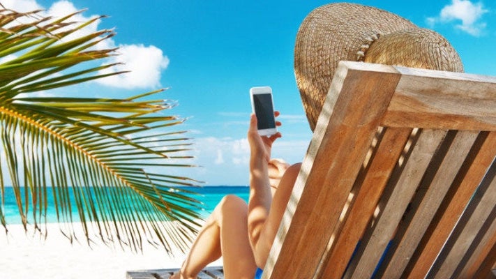 woman on the beach with her phone