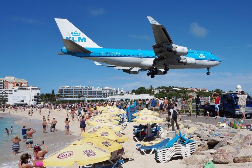 A KLM 747 on Final Approach into SXM Airport. Image courtesy of <a href="http://www.shutterstock.com/pic-235003774/stock-photo-saint-martin-dutch-antilles-november-the-beach-at-maho-bay-is-one-of-the-world-s.html?src=wBO4W7LHRoiW8646FAU-QQ-1-0" target="_blank">Shutterstock</a>.