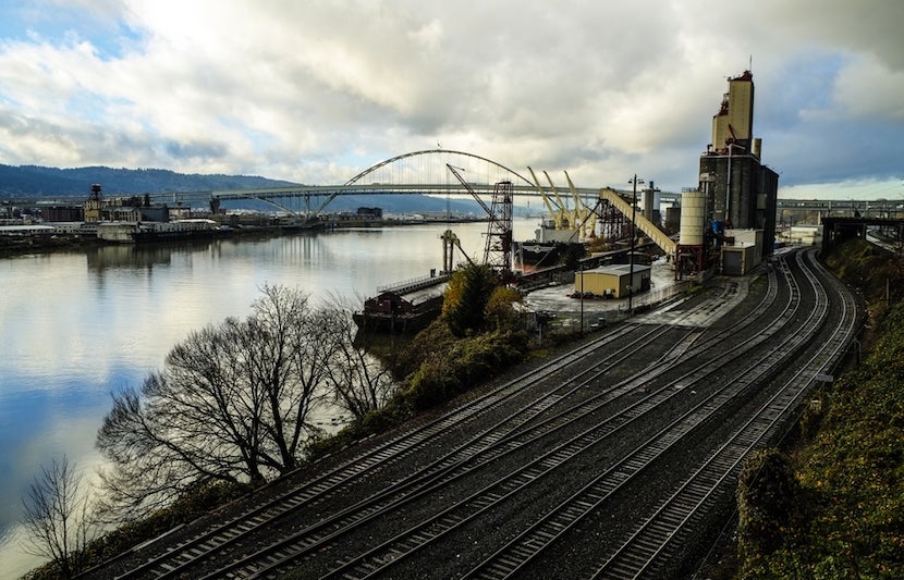 Shipping remains an important industry to Portland, but with a questionable past. Image courtesy of <a href="http://www.shutterstock.com/pic-121934983/stock-photo-railroad-tracks-by-a-harbor-with-ship-loading-cargo.html?src=9YHTDeyNvrRHouY5Kg8gXw-1-23">Shutterstock</a>.