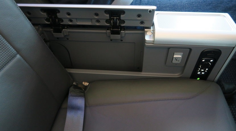 Each premium economy seat has a storage well under one of the armrests.