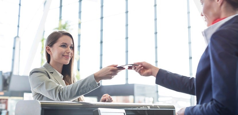 Passenger receiving documents from airport check-in attendant