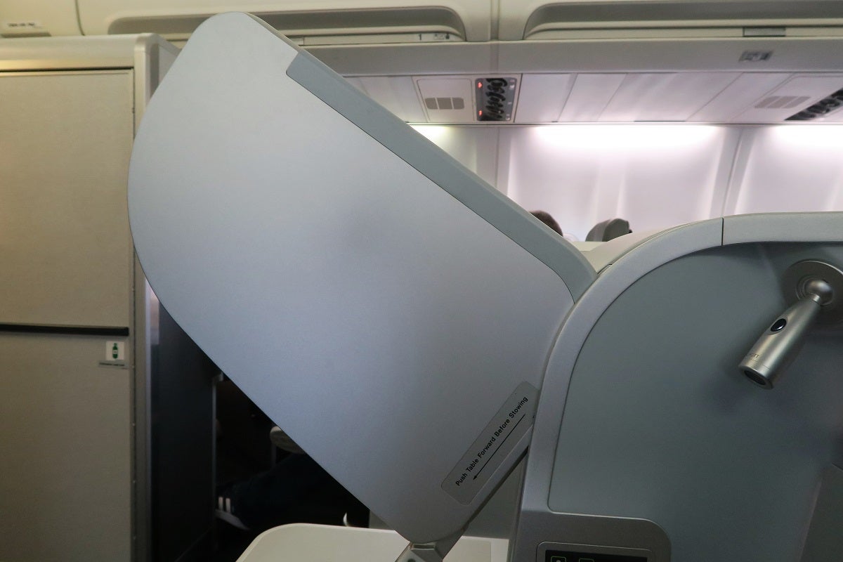 The tray table folds out from between the seat and the storage compartment.