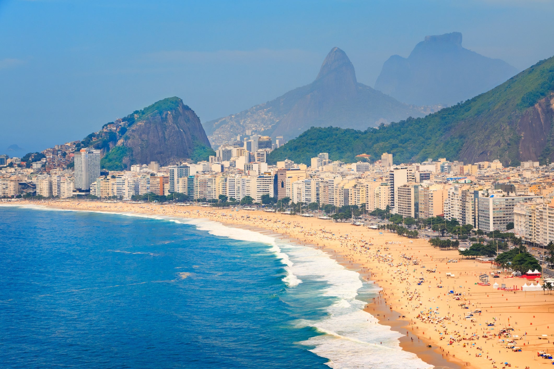 Photo of Copacabana Beach, the ocean and the cityscape of Rio de Janeiro, during summer in Brazil.