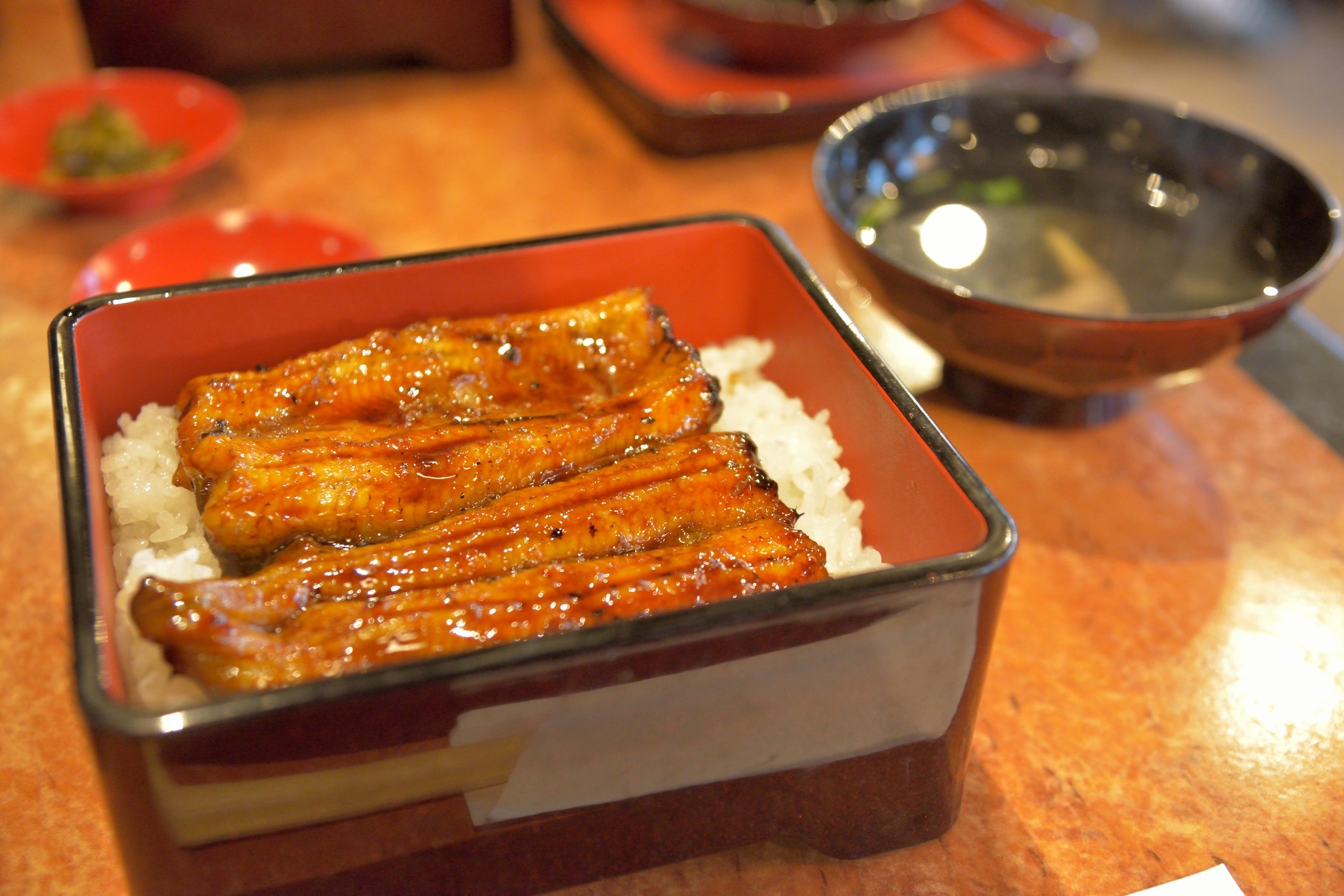 <em>Unaju</em> is <em>unagi</em> on rice served in a lacquered box. Image courtesy of Kosei Saito via Getty Images.