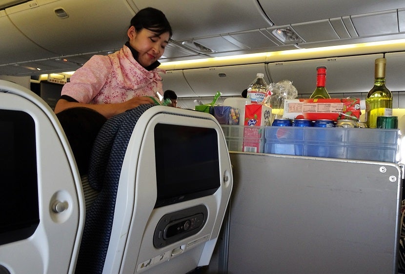 One of five flight attendants in Economy busy at work.
