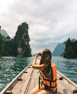 woman sitting on a dock taking a picture