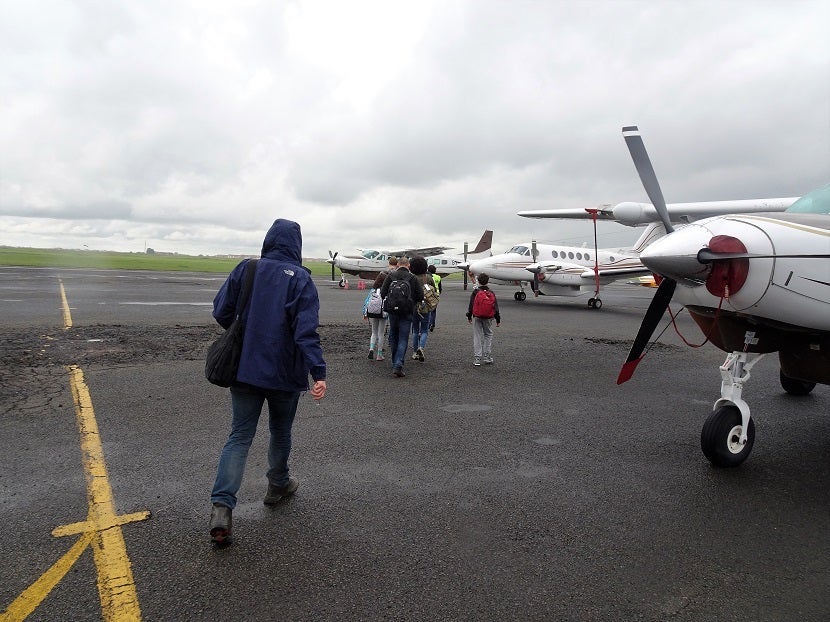 Passengers walk to the aircraft, past several others nearby.