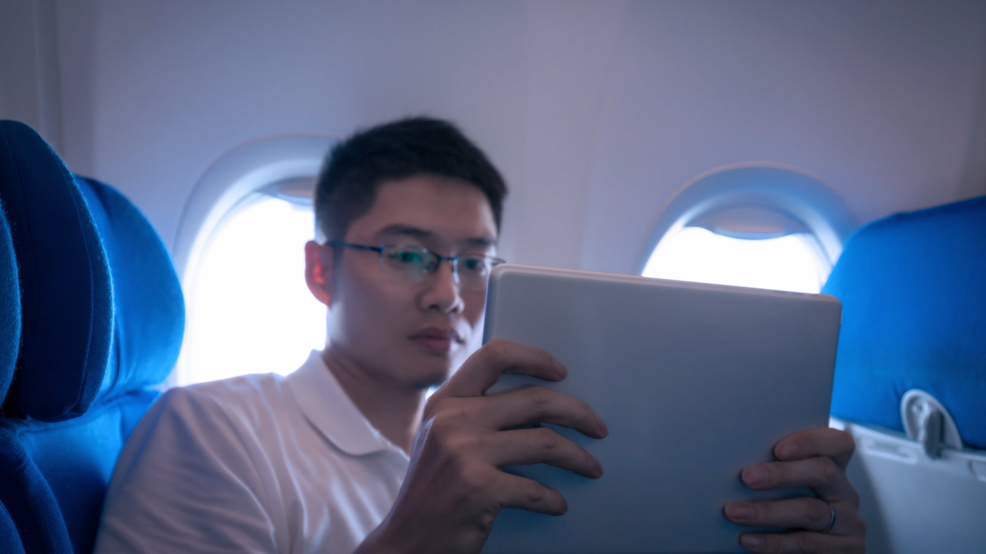 Businessman using digital tablet in airplane travelling