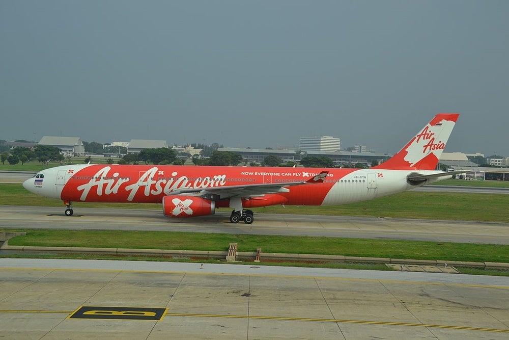 Can you spot the golfers behind the AirAsia plane? Image courtesy of Alec Wilson/Wikipedia.