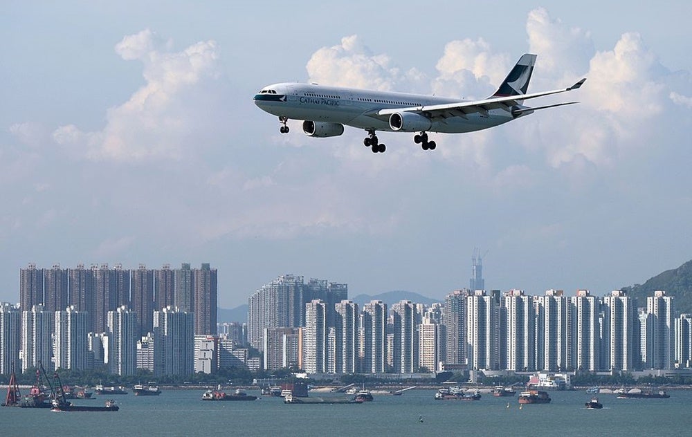 A Cathay Pacific plane flies over the city. Image by Dale de la Rey/Getty Images.