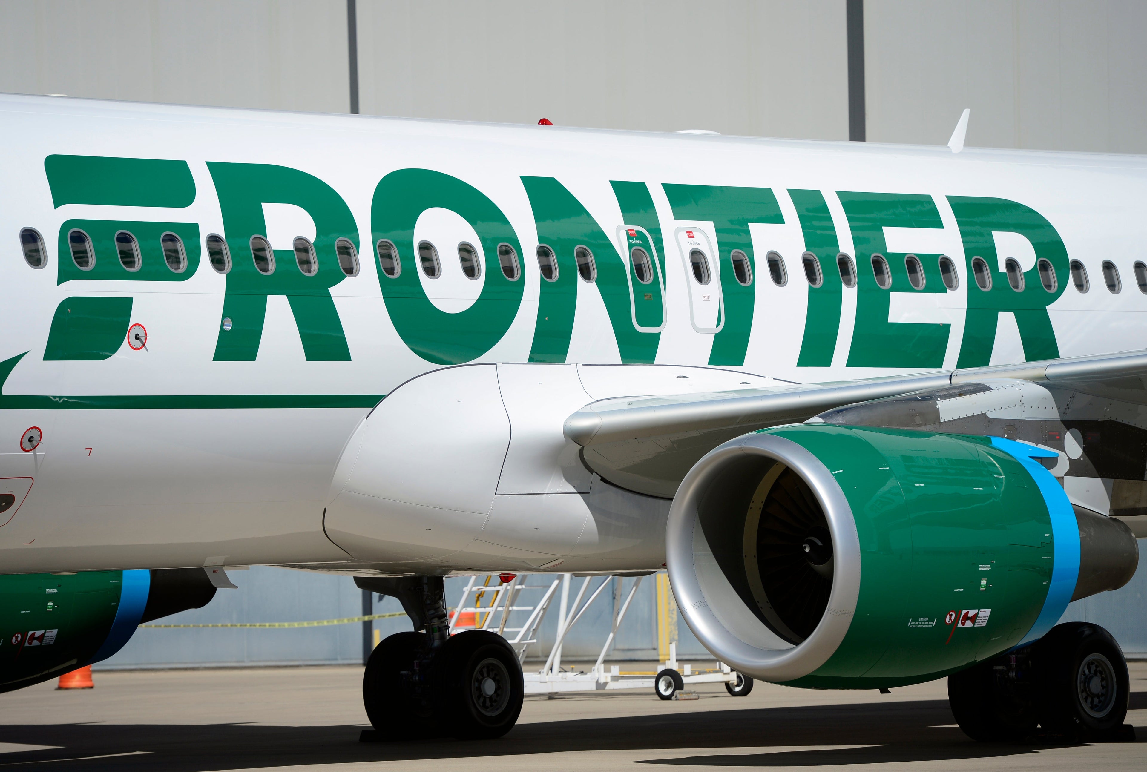 DENVER, CO - SEPTEMBER 9: Frontier employees and executives physically pull a 46-ton Airbus A320 out of the Frontier Airlines hanger at Denver International Airport in Denver. The plane reveals the new paint scheme of the Frontier logo reverting to the stylized "F" to look like that from the logo first introduced in 1978. The iconic animals on the plane's tale will stay and will be featured more prominently extending from the tale to the aft fuselage of the aircraft. (Kathryn Scott Osler/The Denver Post via Getty Images)