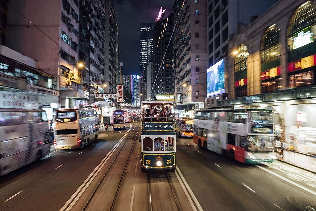 Trams and buses speed through Hong Kong. Photo courtesy of Anthony Kwan via Getty.