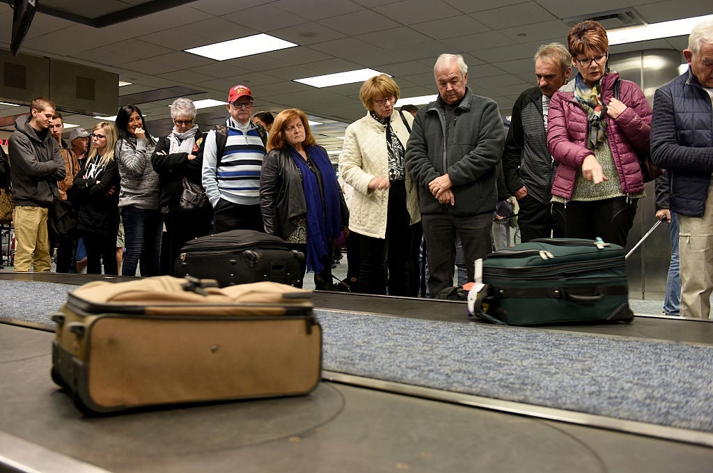 passengers wait for suitcases at baggage claim