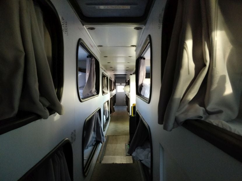 The hallway upstairs on the bus, with pods on each side.