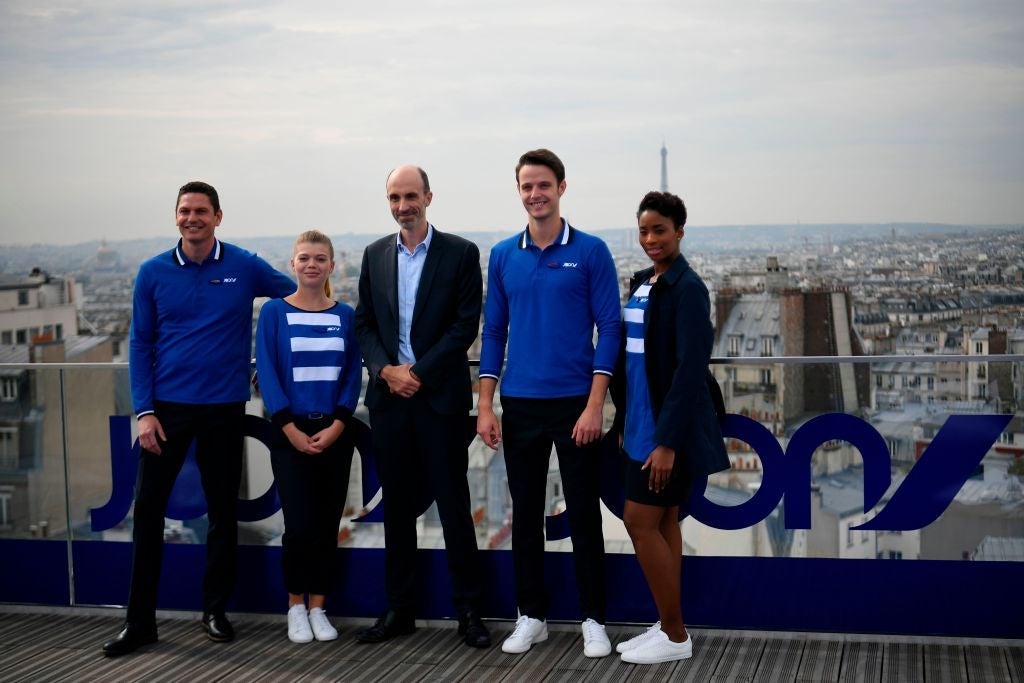 Joon's CEO Jean-Michel Mathieu (C) poses with staff on a roof in Paris on September 25, 2017 during the launching of Joon, the new lower-cost airline subsidiary of Air France.Joon's activities will start on December 1, 2017 with intra-Europe flights and long haul flights during summer 2018. / AFP PHOTO / Lionel BONAVENTURE (Photo credit should read LIONEL BONAVENTURE/AFP/Getty Images)