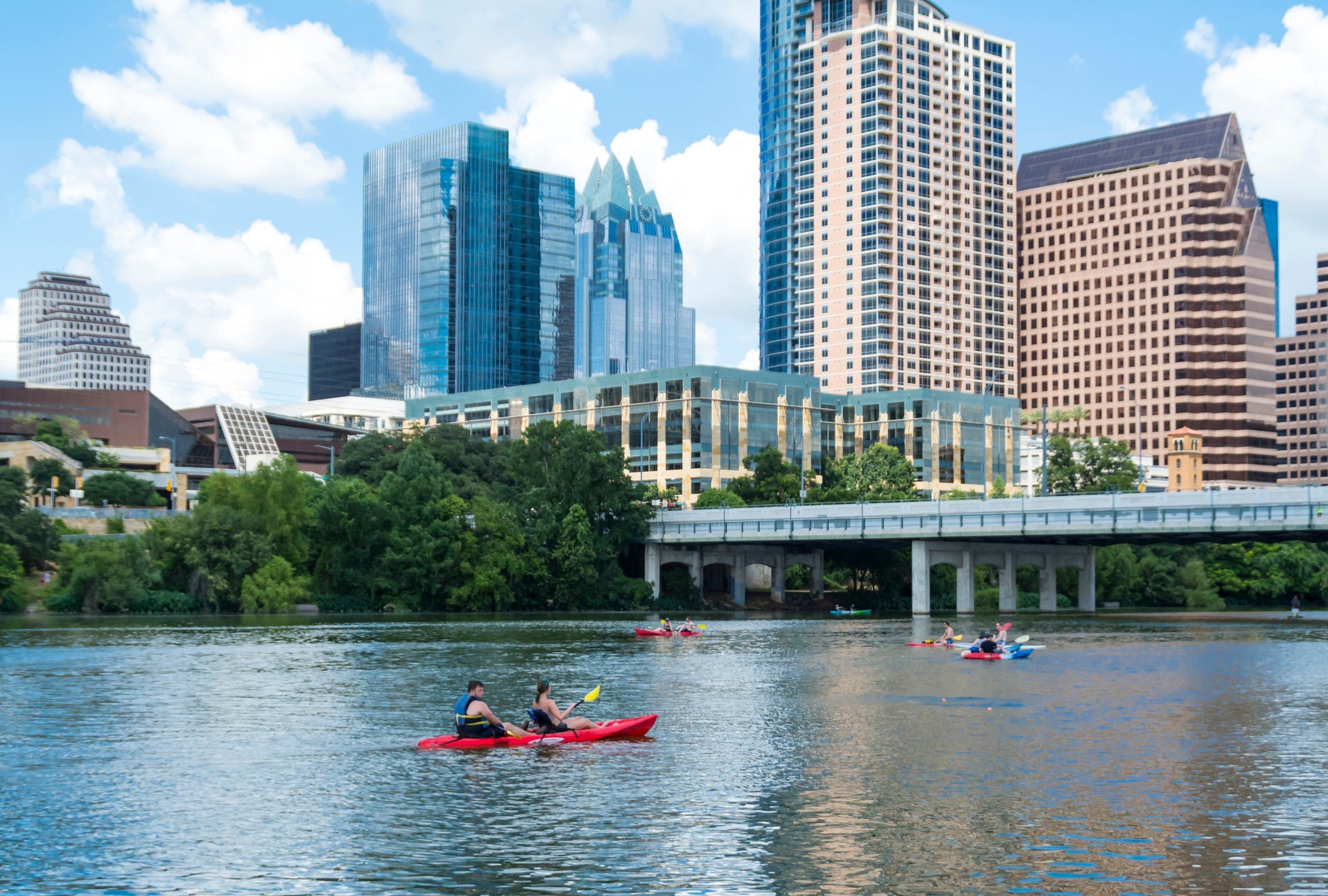 People canoeing on Lady Bird Lake in Austin with the Austin Skyline in the background. (Photo courtesy of Getty Images)