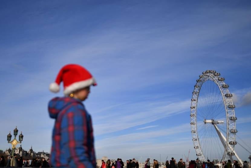 A girl in a santa hat is seen as people walk over Westminster bridge in London, on December 9, 2017 with the London Eye in the background. Britain and the European Union reached a historic deal on Brexit divorce terms on December 8, but Brussels swiftly warned that even harder talks lie ahead on a future relationship after the split. / AFP PHOTO / BEN STANSALL (Photo credit should read BEN STANSALL/AFP/Getty Images)