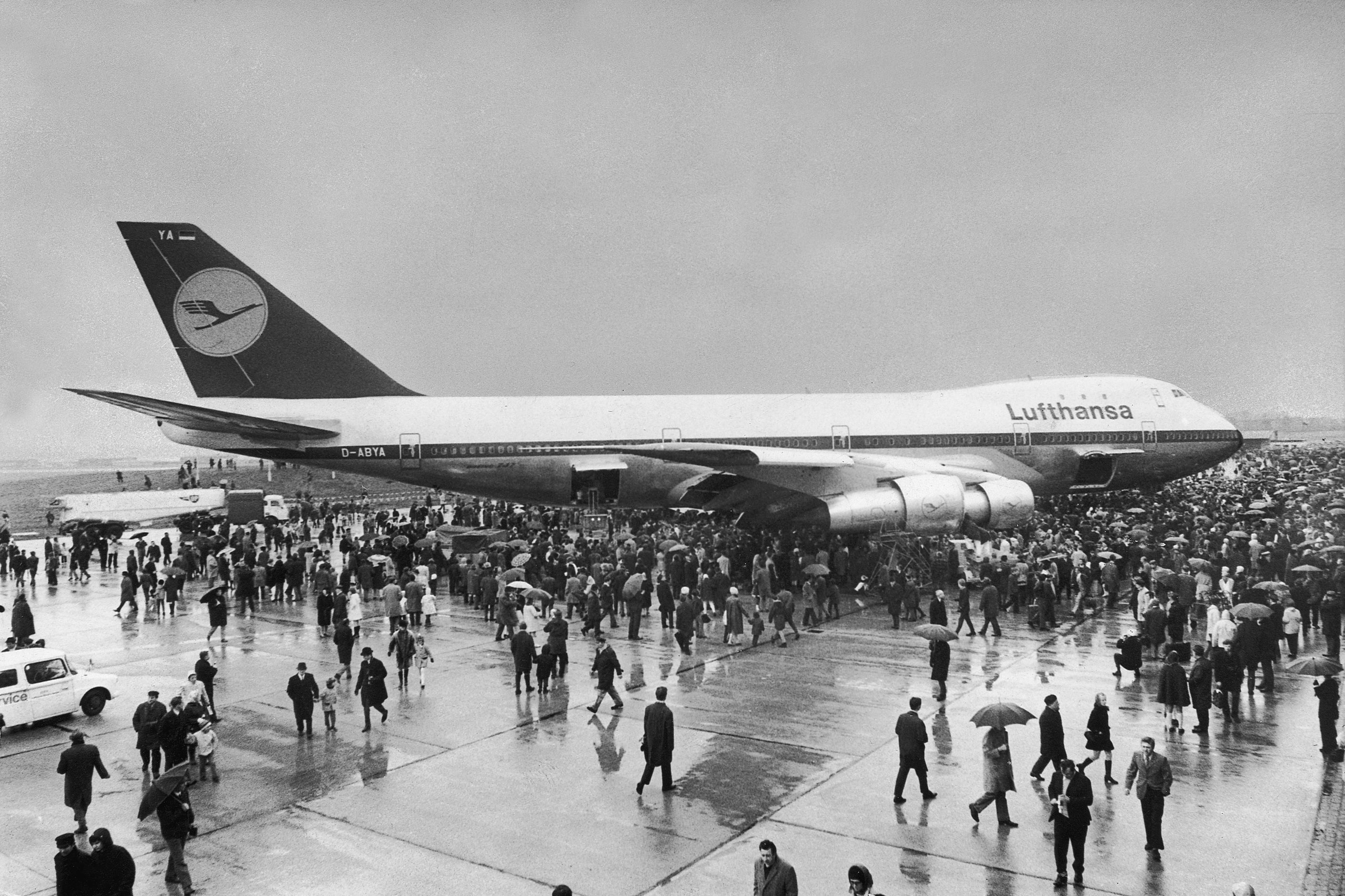 (GERMANY OUT) Trotz Regen und Wind gab es am Ostermontag, den 30.3.1970, einen Besucher-Ansturm auf dem Hamburger Flughafen. Der erste Jumbojet Boeing 747 traf aus seiner Geburtsstadt Seattle/USA in der Hansestadt ein. An Bord hatte der Riesenvogel als Ehrengäste den Bundesverkehrsminister Georg Leber, Hamburgs Wirtschaftssenator Helmuth Kern und Lufthansa-Vorstandsmitglied Prof. Höltje. Unzählige Menschen umdrängten die 70,51 Meter lange Maschine auf dem Vorfeld vor der Lufthansawerft, bevor sie zum Ausrüsten in die Halle kam. (Photo by Conti-Press/ullstein bild via Getty Images)