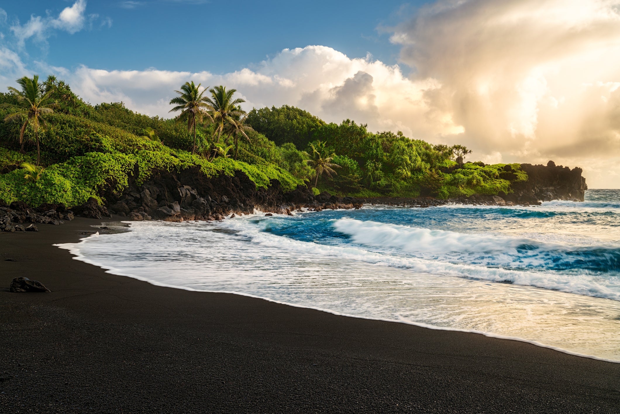 The Road to Hana is an amazing and probably Maui's most popular drive. One of the must stops on the way is the black sand beach. The water is cold, treacherous and shark infested. Waianapanapa State Park boasts a black sand beach that's simply unparalleled on the island of Maui, or anywhere else for that matter. It's nestled in a private cove, the pitch black granules glisten, dark and mysterious — there is something about it that draws people here. Created long, long ago by the rough surf pounding on a fresh, bubbling lava flow, courtesy of Haleakala. It took a millennia or more to be ground down into a beach. The beauty of the turquoise coastal beaches of Hawaii are almost indistinguishable from those of the Bahamas, French Polynesia, Malau, Hawaii, Cancun, Costa Rica, Florida, Maldives, Cuba, Fiji, Bora Bora, Puerto Rico, Honduras, Navagio Beach, Shipwreck Beach, Smugglers Cove, Zakynthos, Ionian Islands, or other tropical vacation travel destinations.