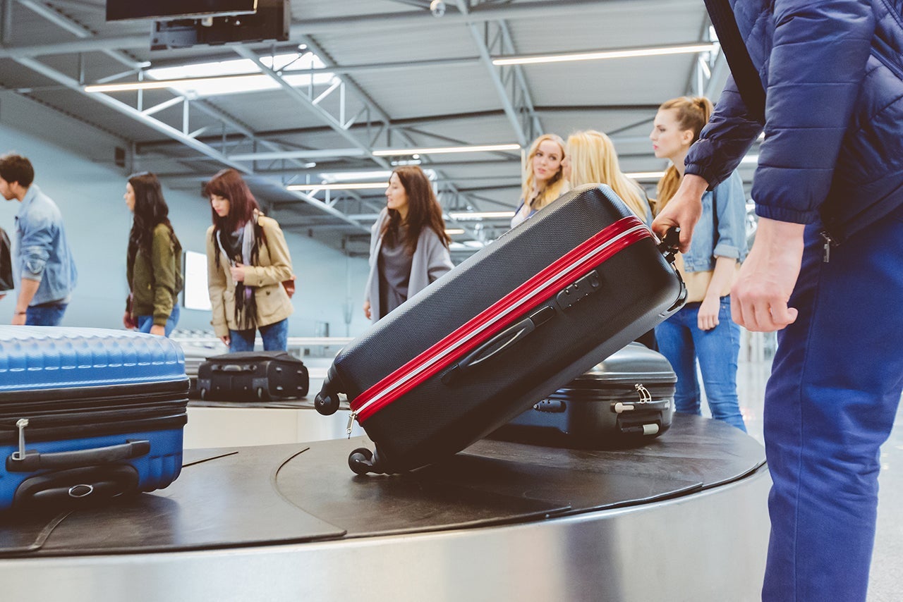 People waiting at baggage claim line terminal of the international airport. Airplane travelers waiting for luggage from a conveyor belt. (Photo by izusek/Getty Images)
