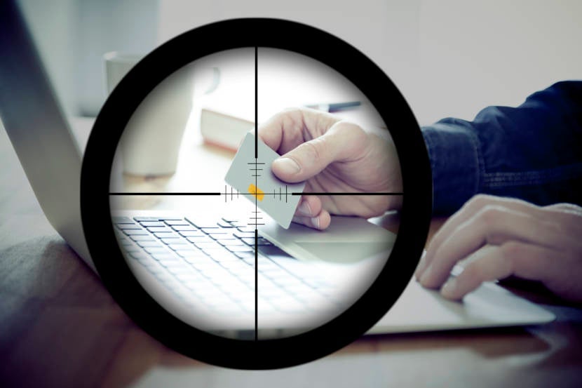 Looking through a scope with a target, centered on a person's credit card