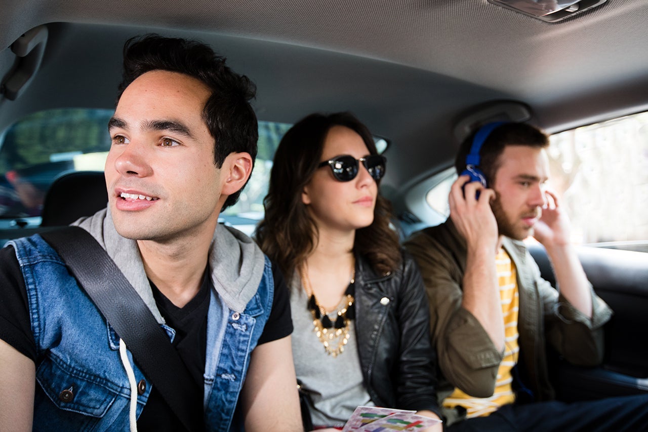 Medium shot of two young men and a young woman riding in a car. (Photo courtesy Uber)