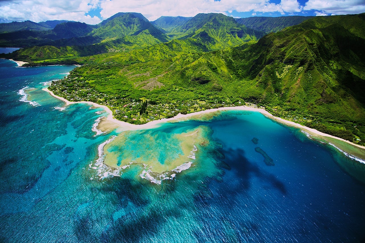 An aerial photo of Tunnels beach. Tunnels is located on Kauai's North Shore and is named after the "tunnels" that snorkelers and divers can observe when navigating the reef. This is one of many great snorkeling spots in Hawaii, and also one of the better surfing beaches. (Photo by bjonesmedia/Getty Images)