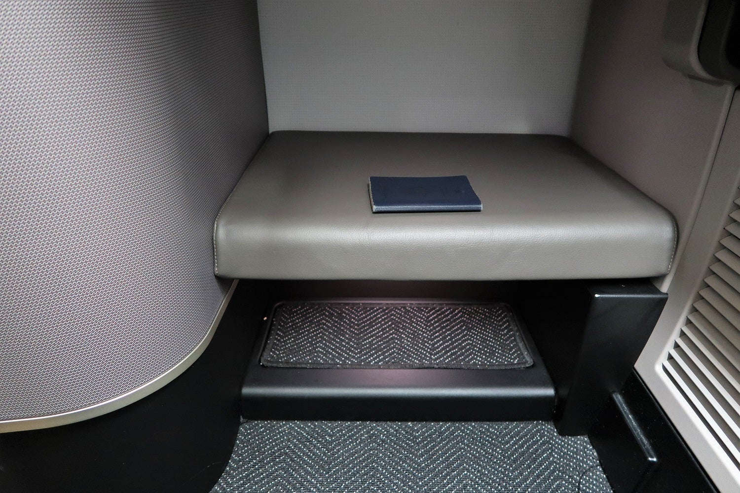 The extra-large footwell on seat 9L with my beat-up passport for reference.