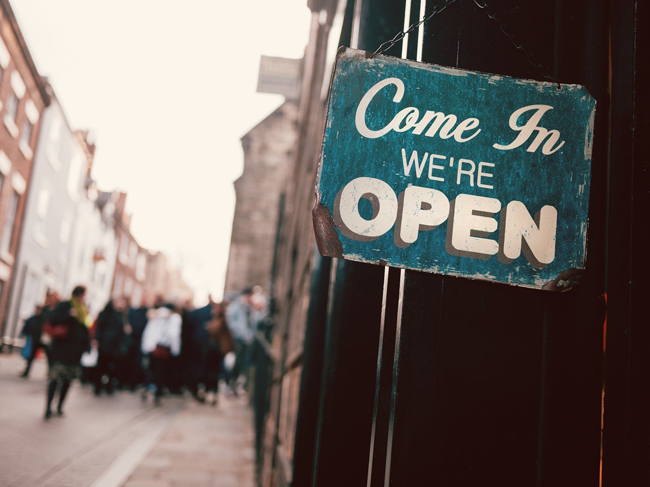 an "com in we're open" sign on a door