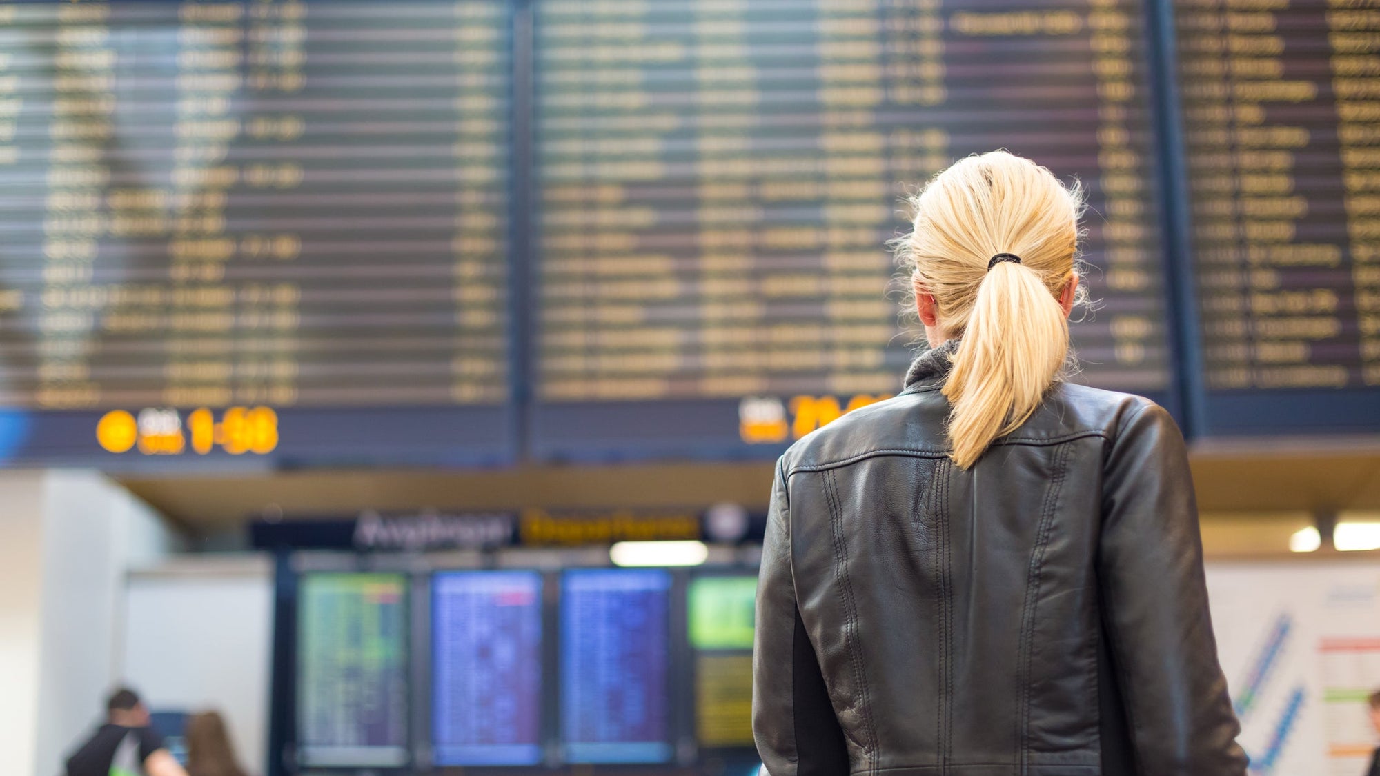 Female traveller checking flight departures board.