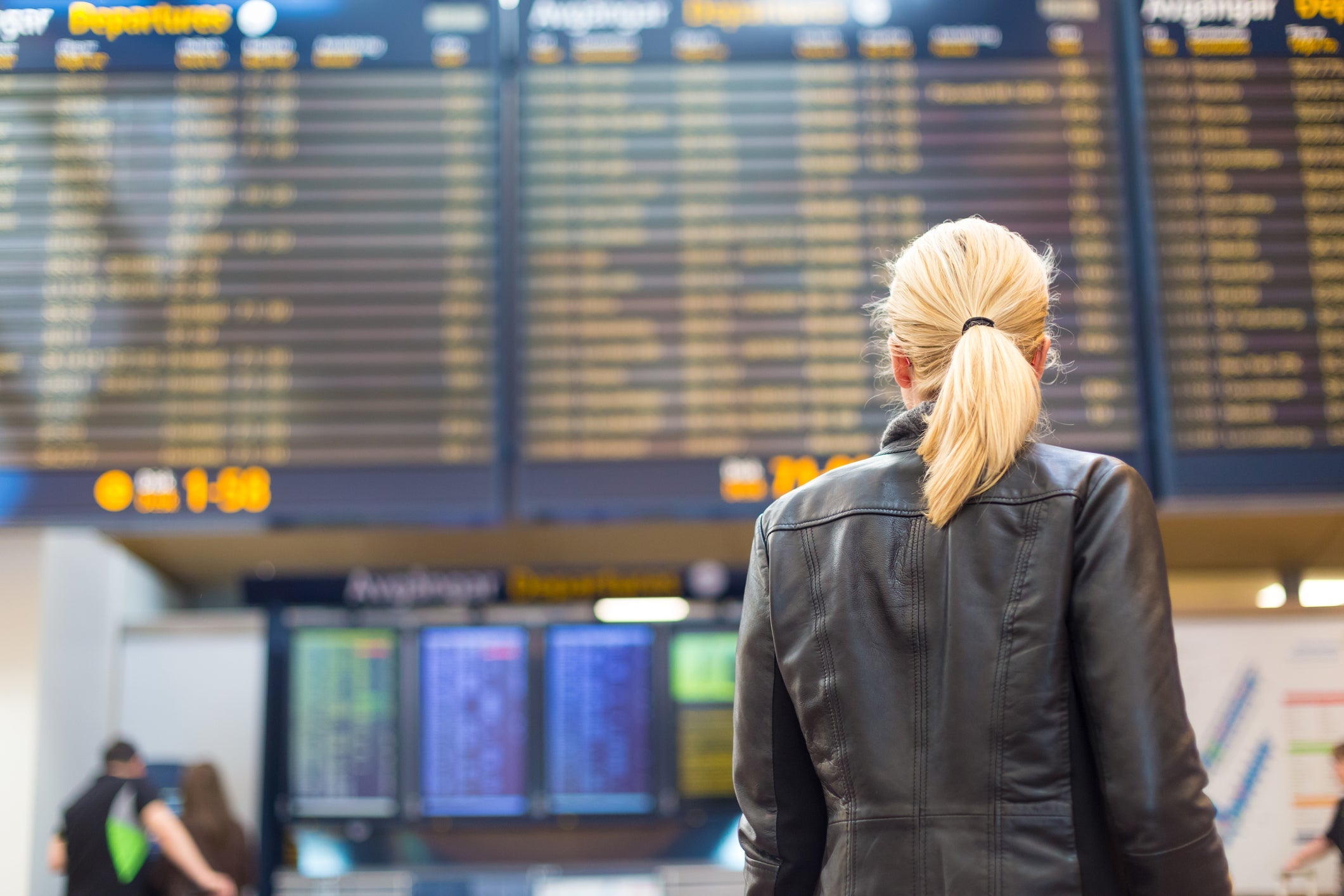 woman at airport checking departure boards