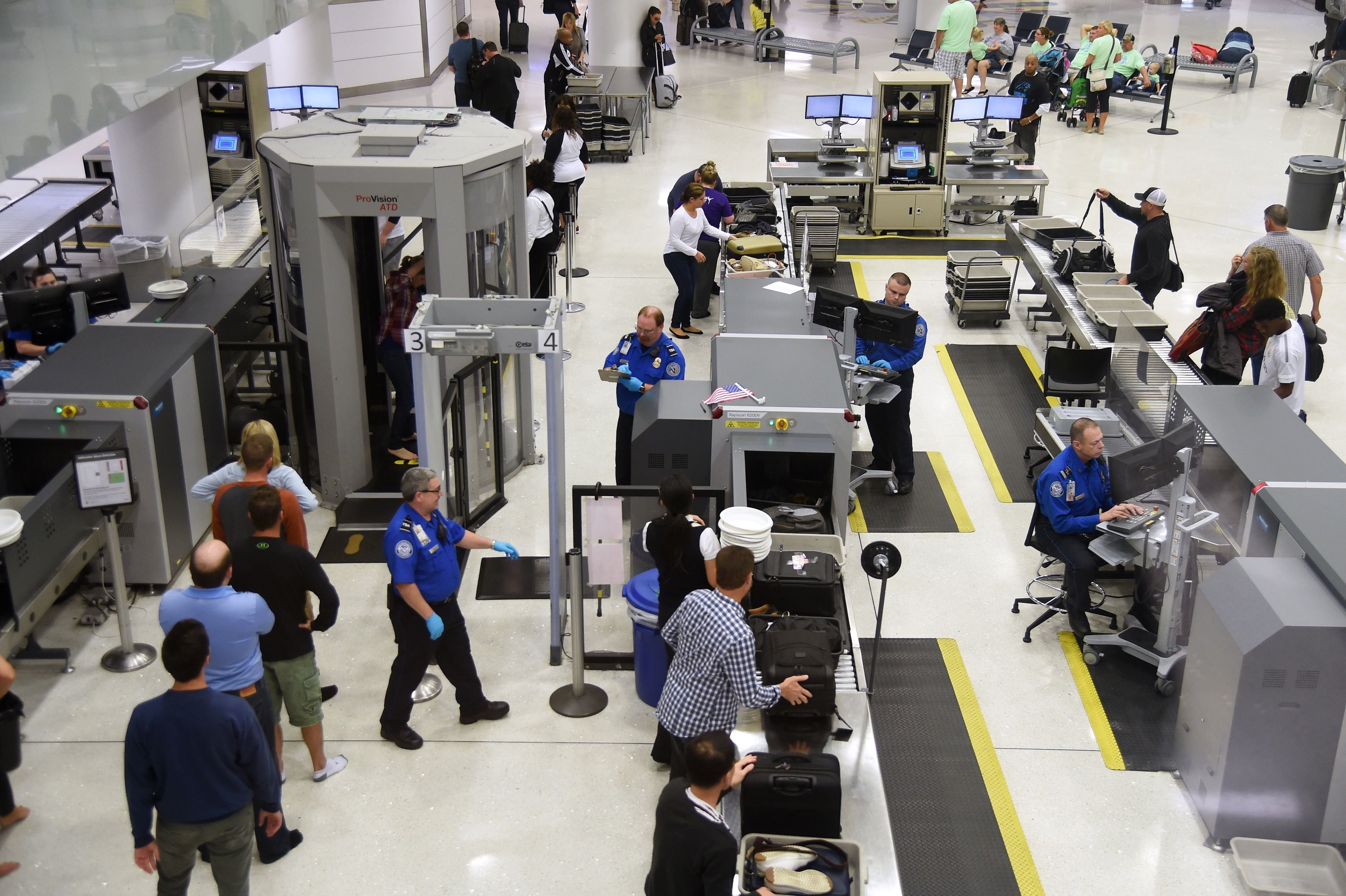 US Transportation Security Administration (TSA) officers inspect airline passengers before they board their flights, at LambertSt. Louis International Airport in St Louis, Missouri, October 10, 2016. / AFP / Robyn Beck (Photo credit should read ROBYN BECK/AFP/Getty Images)