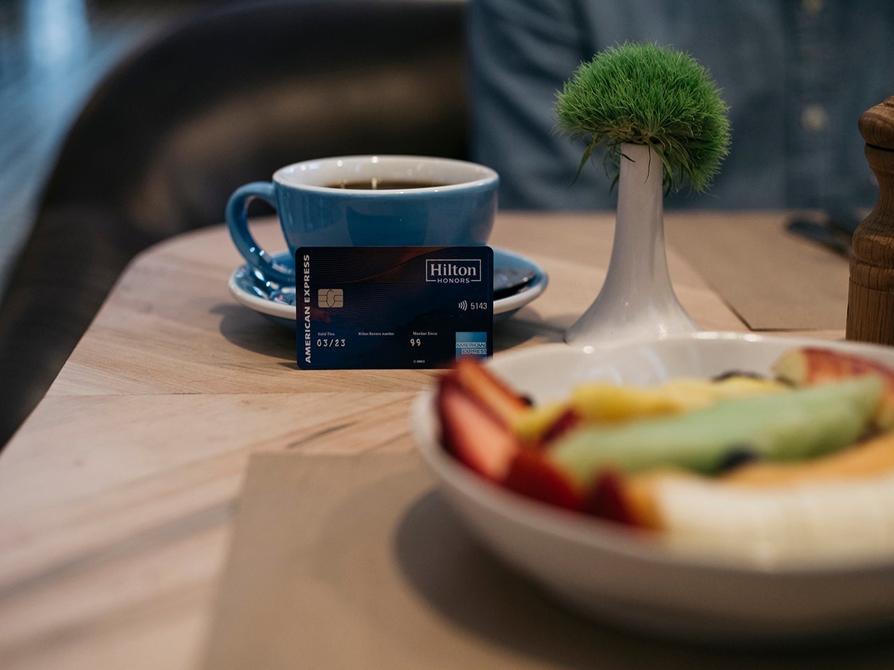 a credit card leaning against a coffee mug