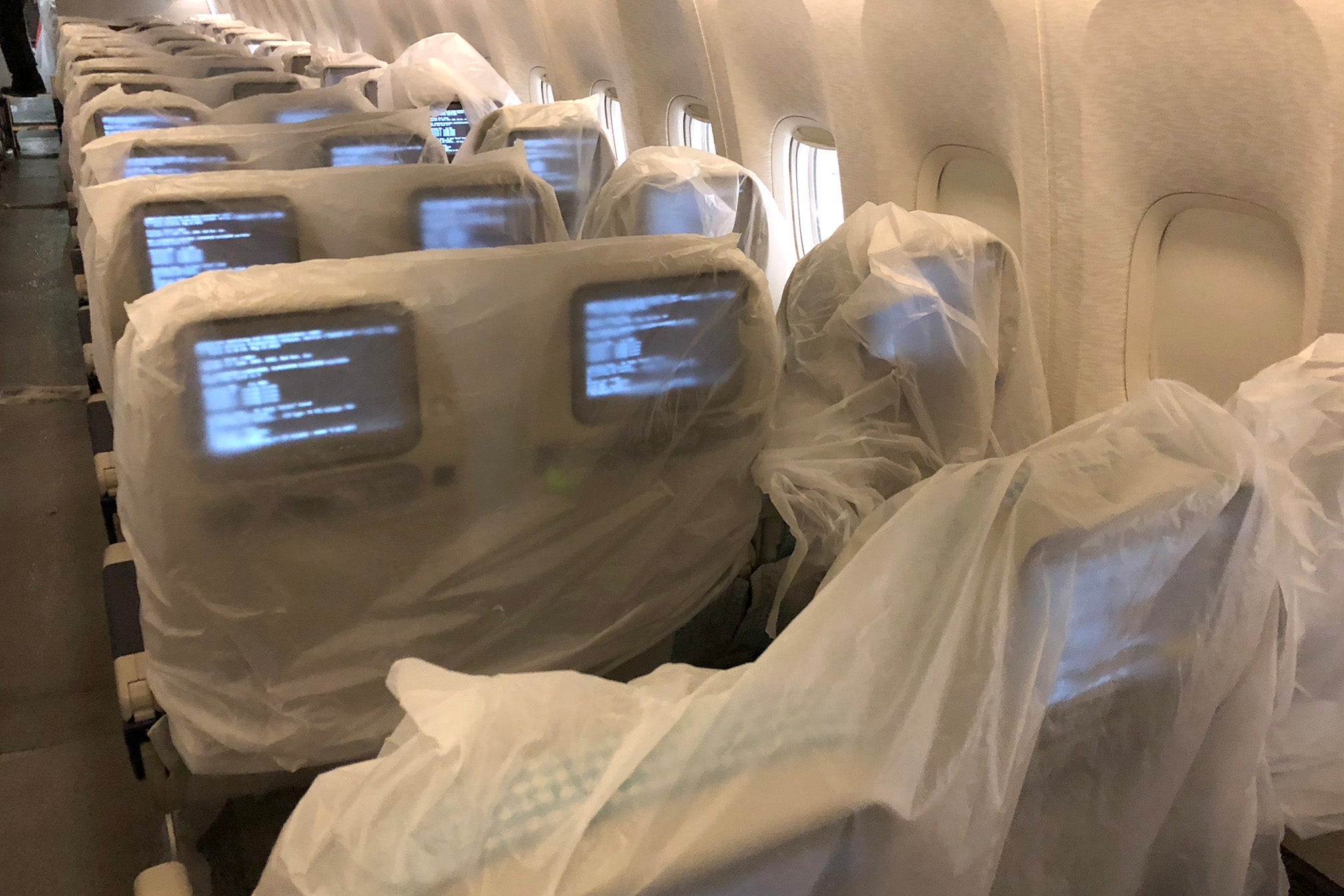 Technicians install in-flight entertainment software shortly after re-installing the economy section. Photo by Zach Honig.