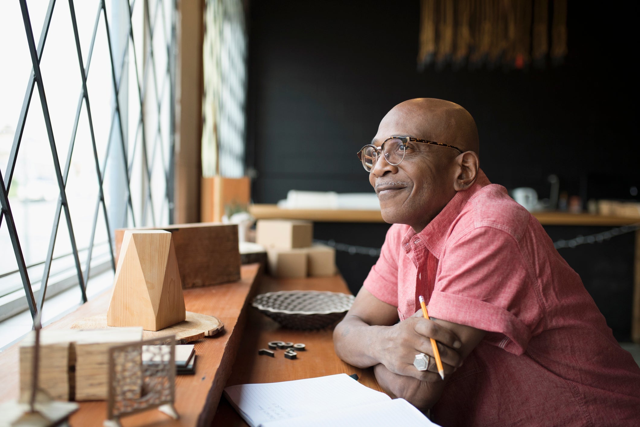 a person smiles while looking out a window