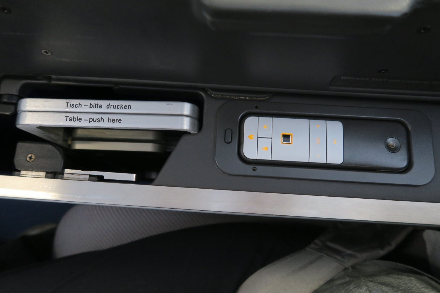 The tray table and IFE remote are stored in the center console.