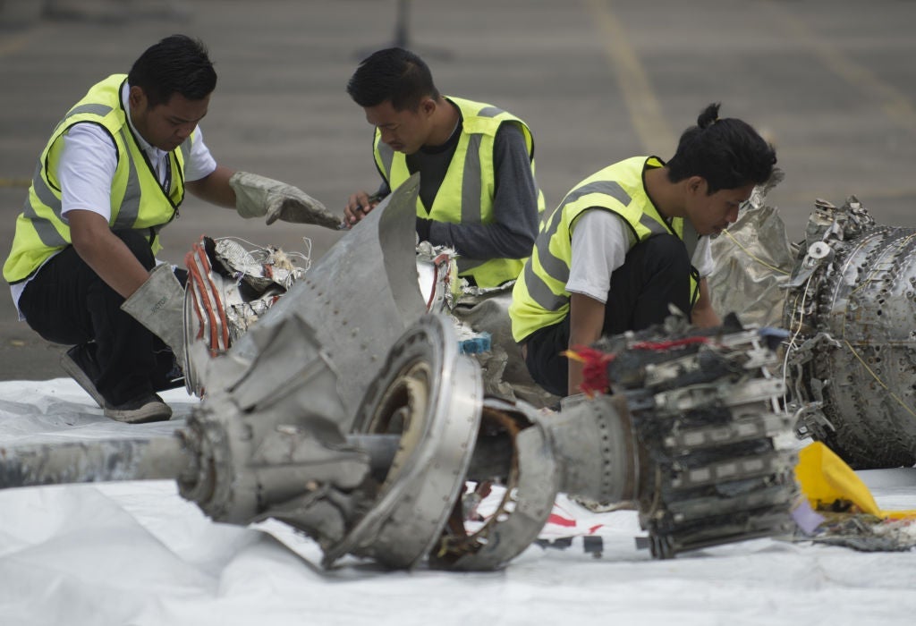 Investigators examine engine parts from the ill-fated Lion Air flight JT 610 at a port in Jakarta on November 7, 2018, after they were recovered from the bottom of the Java sea. - The Indonesian Lion Air jet that plunged into the Java Sea on October 29, killing all 189 on board, had an air speed indicator problem on its fatal flight and on three previous journeys, the country's transportation watchdog said on November 6. (Photo by BAY ISMOYO / AFP) (Photo credit should read BAY ISMOYO/AFP/Getty Images)