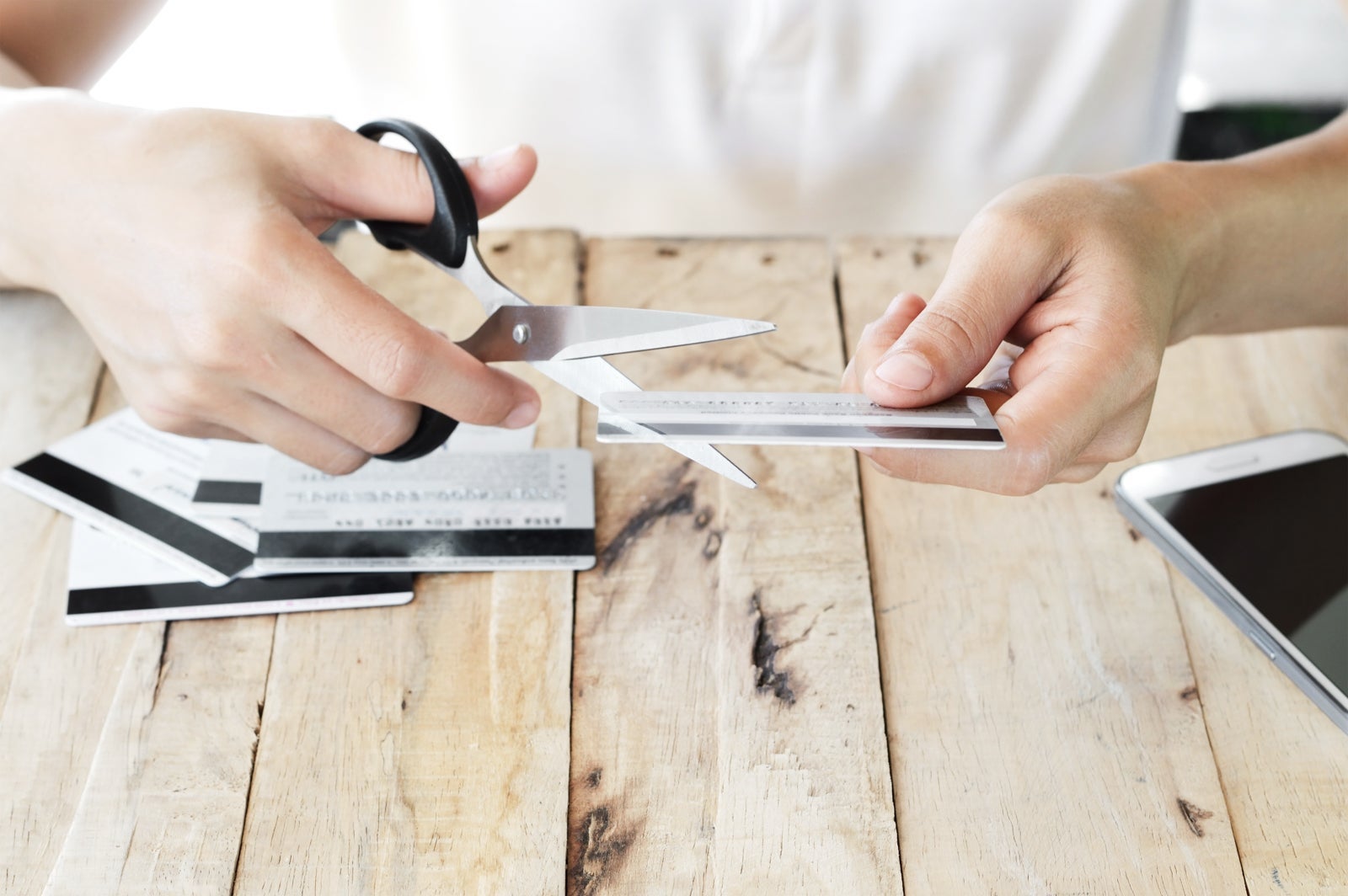 A person cutting up credit cards